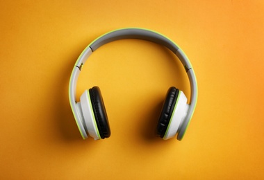 Wireless headphones on color background, top view