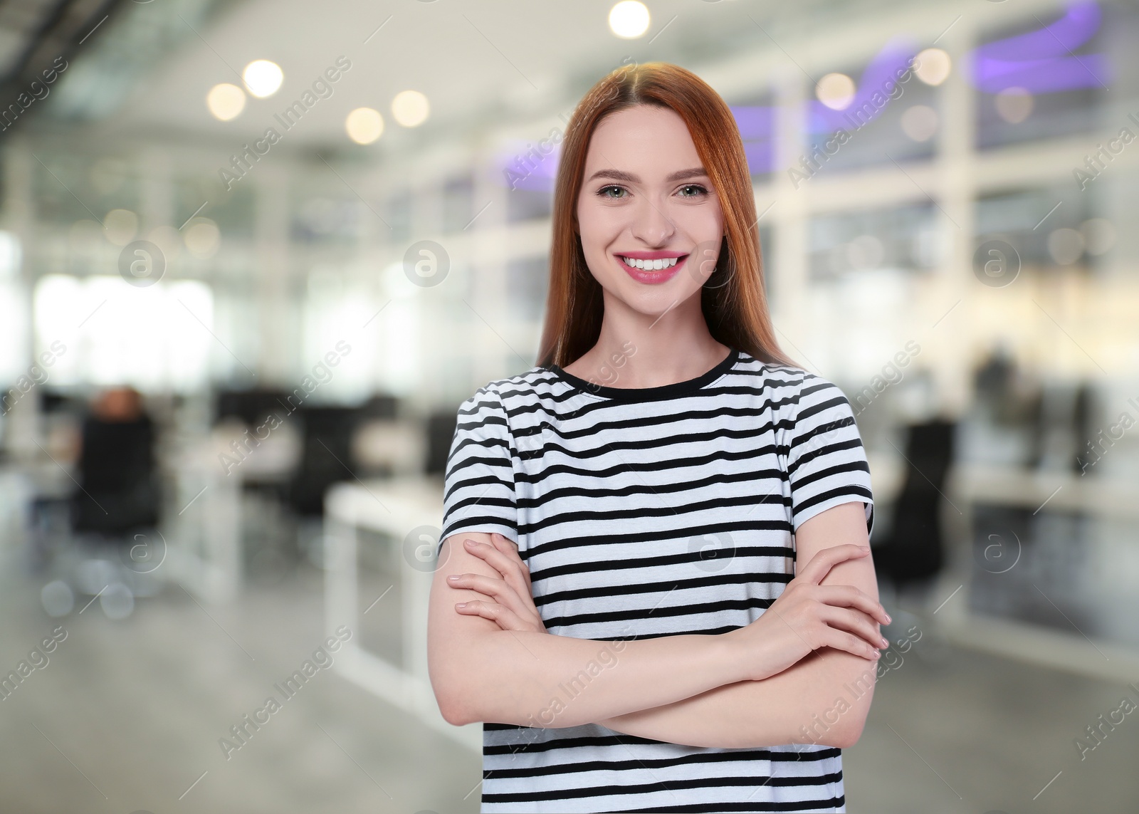 Image of Portrait of happy woman in office. Pretty girl looking at camera and smiling on blurred background