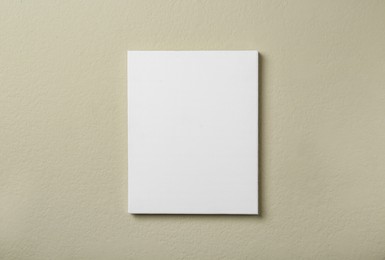 Photo of Blank canvas on beige wall. Space for design