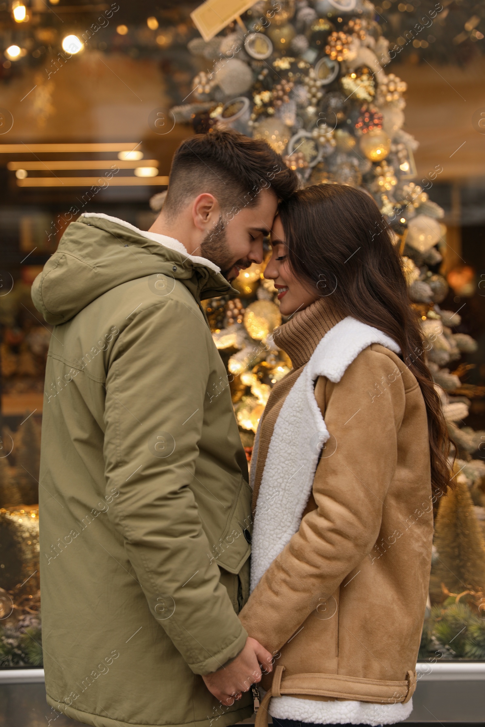 Photo of Lovely couple near store decorated for Christmas outdoors