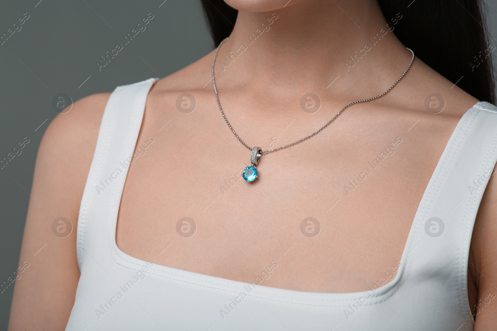 Photo of Woman with elegant necklace on dark grey background, closeup