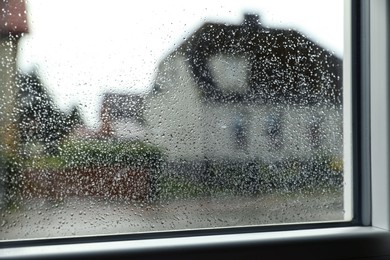 Photo of Blurred view of city street from window on rainy day