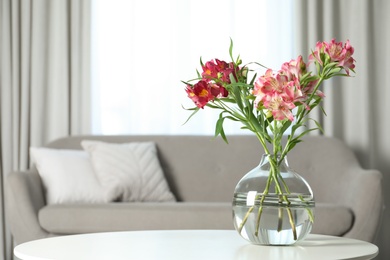 Photo of Vase with beautiful alstroemeria flowers on table in living room, space for text. Stylish element of interior design