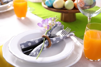 Photo of Festive Easter table setting with flower, closeup view