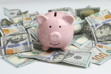 Photo of Money exchange. Dollar banknotes and piggy bank on white background, closeup