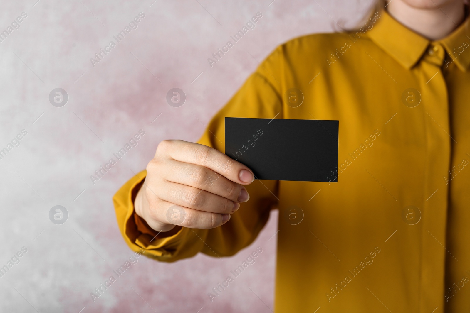 Photo of Woman holding blank business card on pink background, closeup. Mockup for design