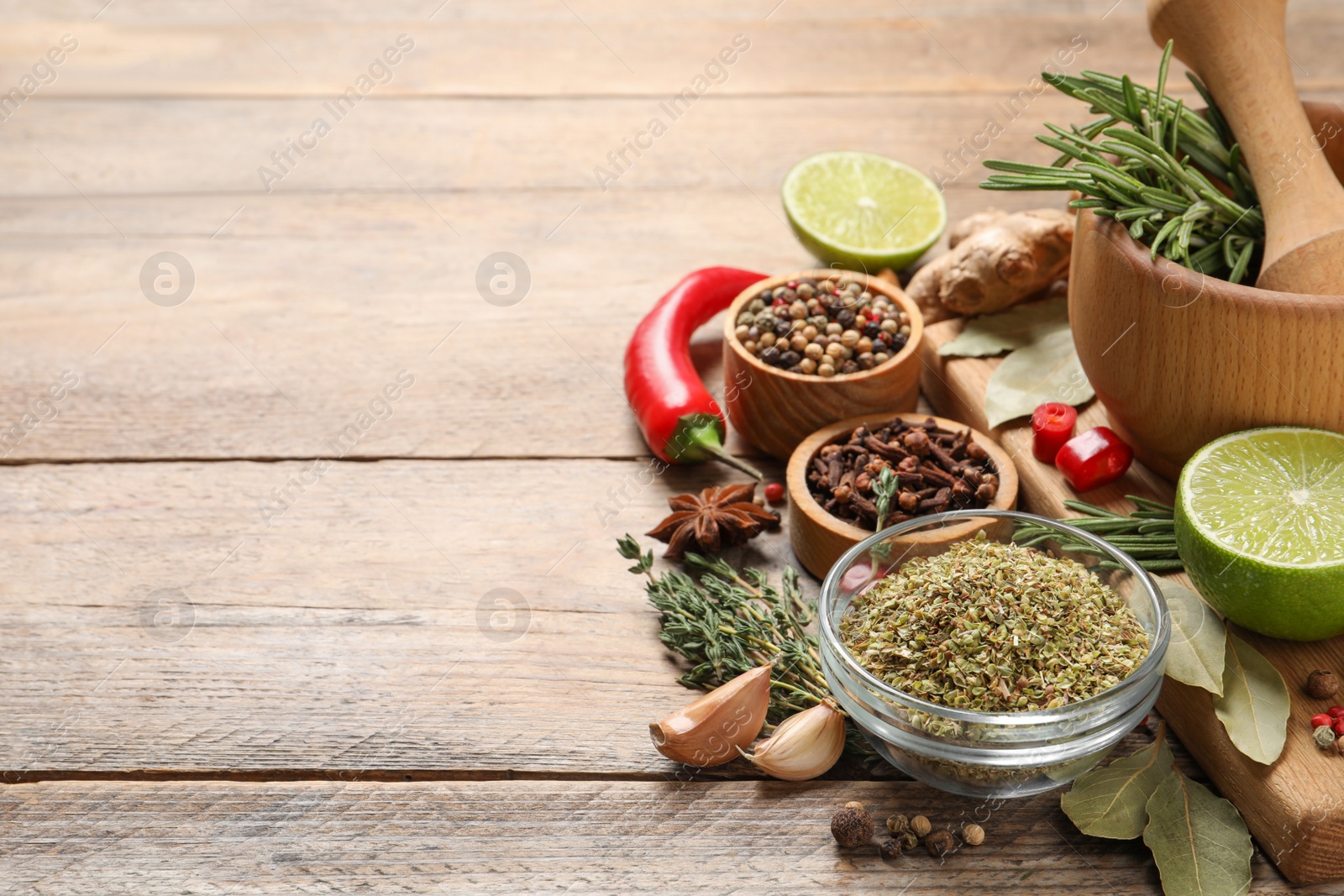 Photo of Different natural spices and herbs on wooden table, space for text