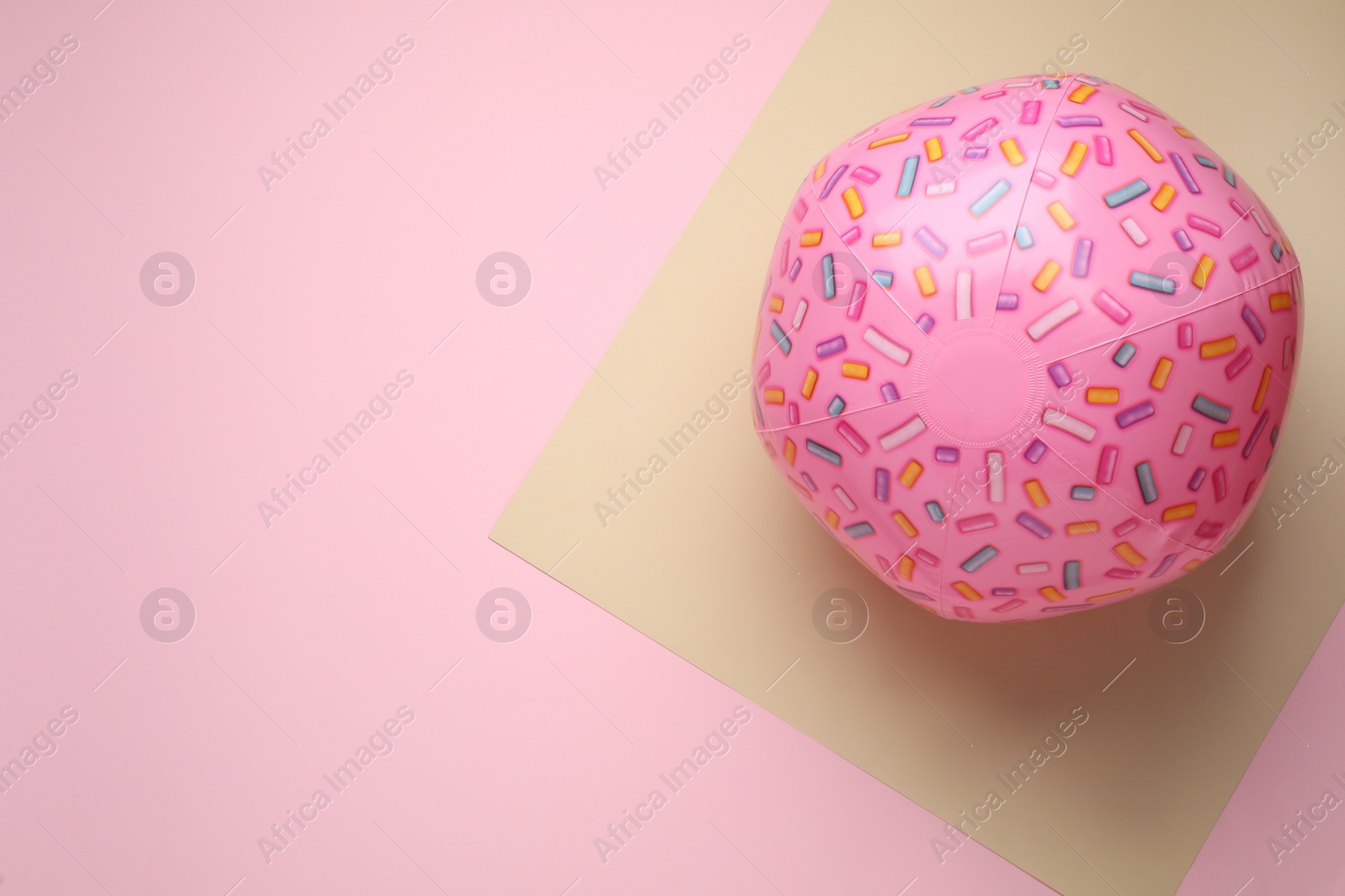 Photo of Pink beach ball on color background, top view. Space for text