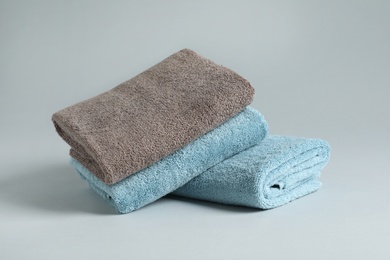 Photo of Fresh fluffy folded towels on grey background