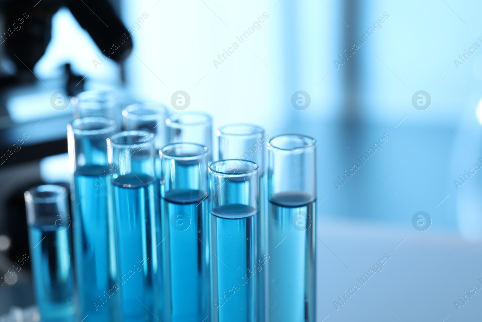 Photo of Test tubes with light blue liquid in laboratory, closeup