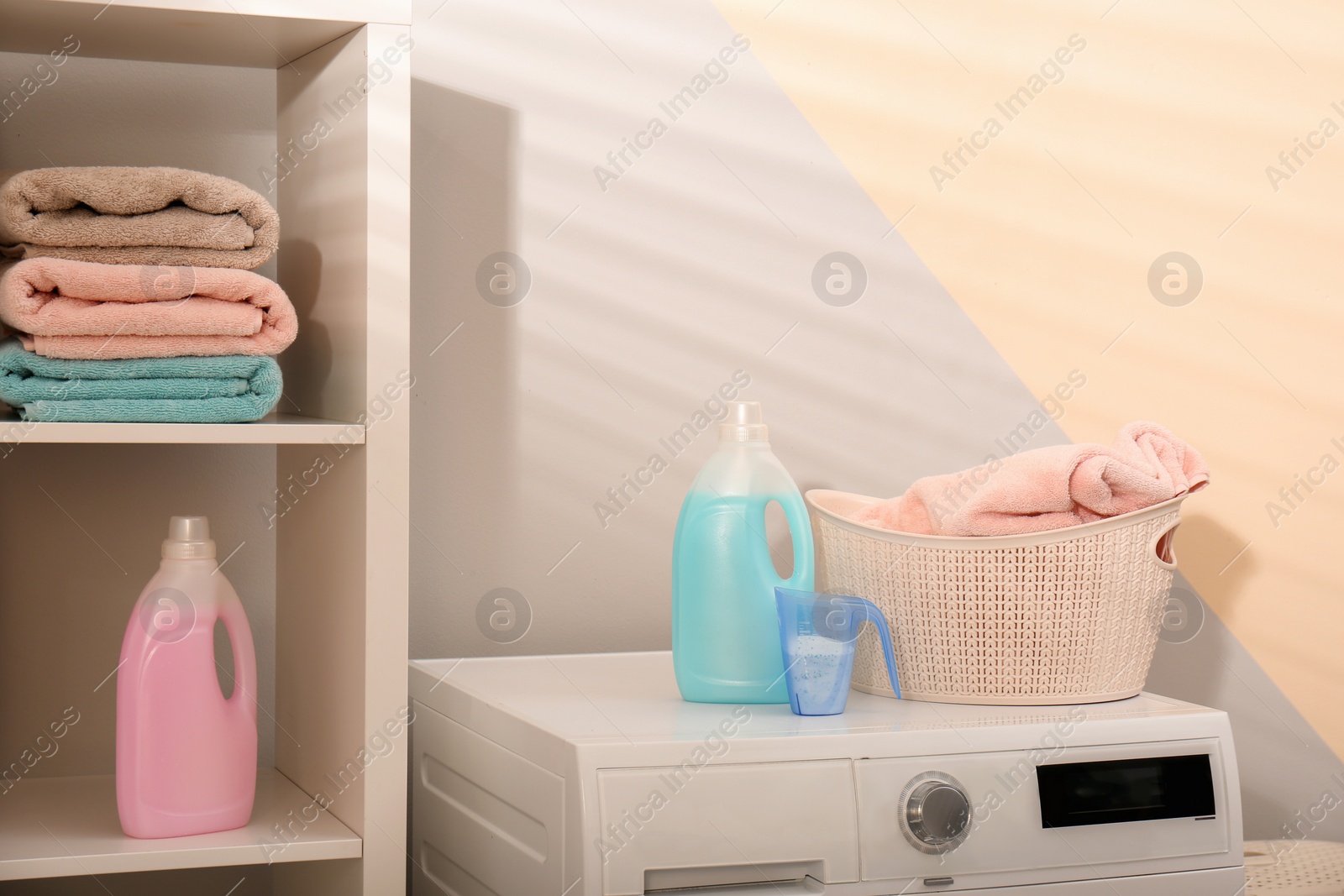 Photo of Detergents and laundry basket on washing machine in bathroom