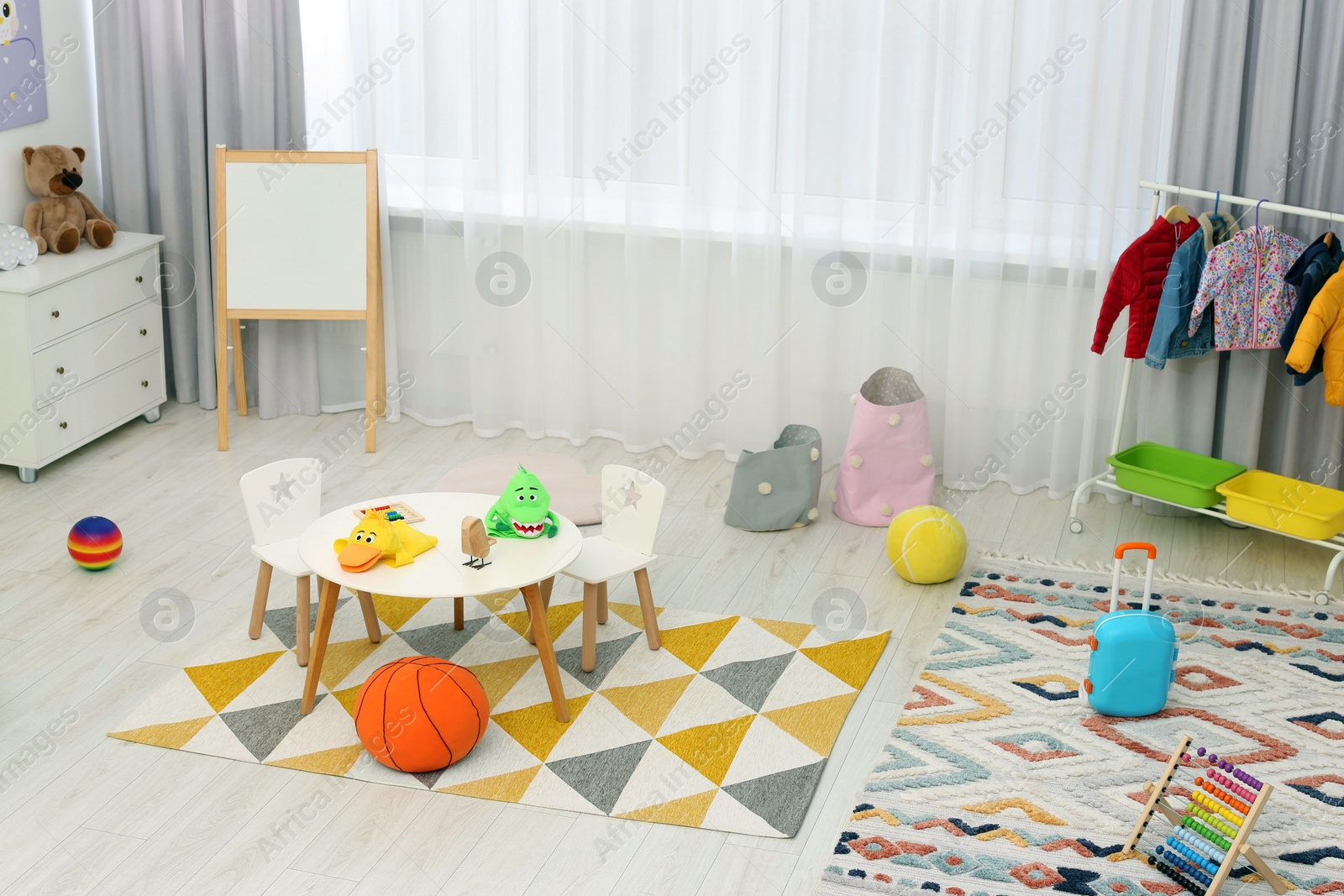 Photo of Child`s playroom with different toys and modern furniture. Stylish kindergarten interior