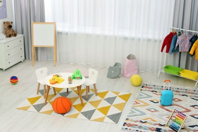 Photo of Child`s playroom with different toys and modern furniture. Stylish kindergarten interior