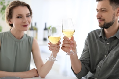 Photo of Young couple with glasses of delicious wine indoors