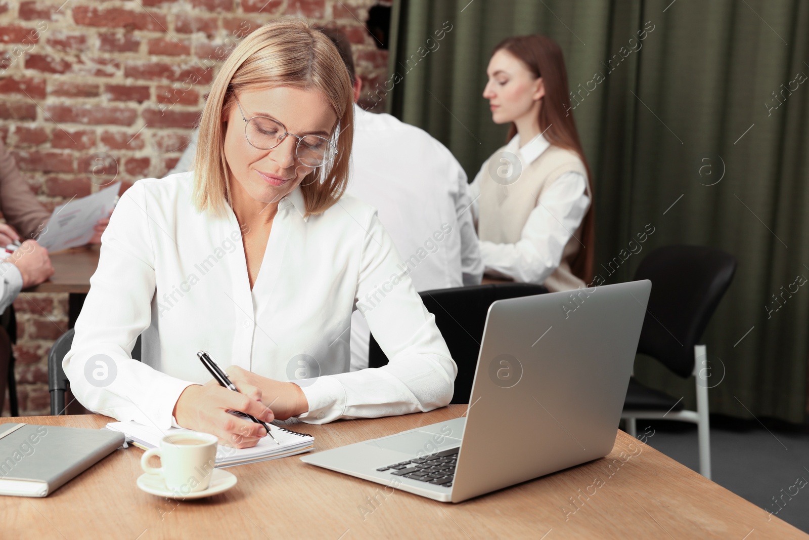 Photo of Businesswoman and her employees in office. Lady boss