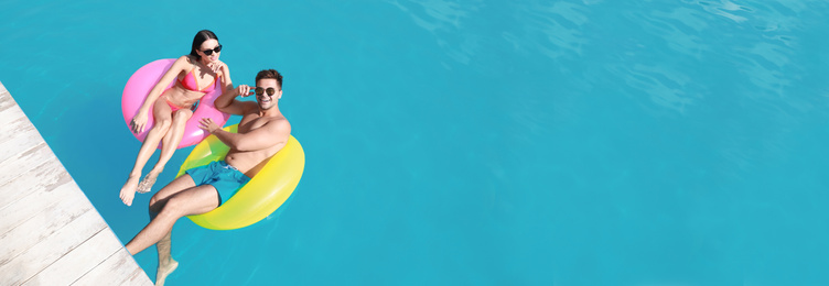 Image of Happy young couple at swimming pool, space for text. Banner design