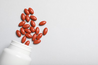 Photo of Pills, bottle and space for text on light grey background, flat lay. Anemia concept