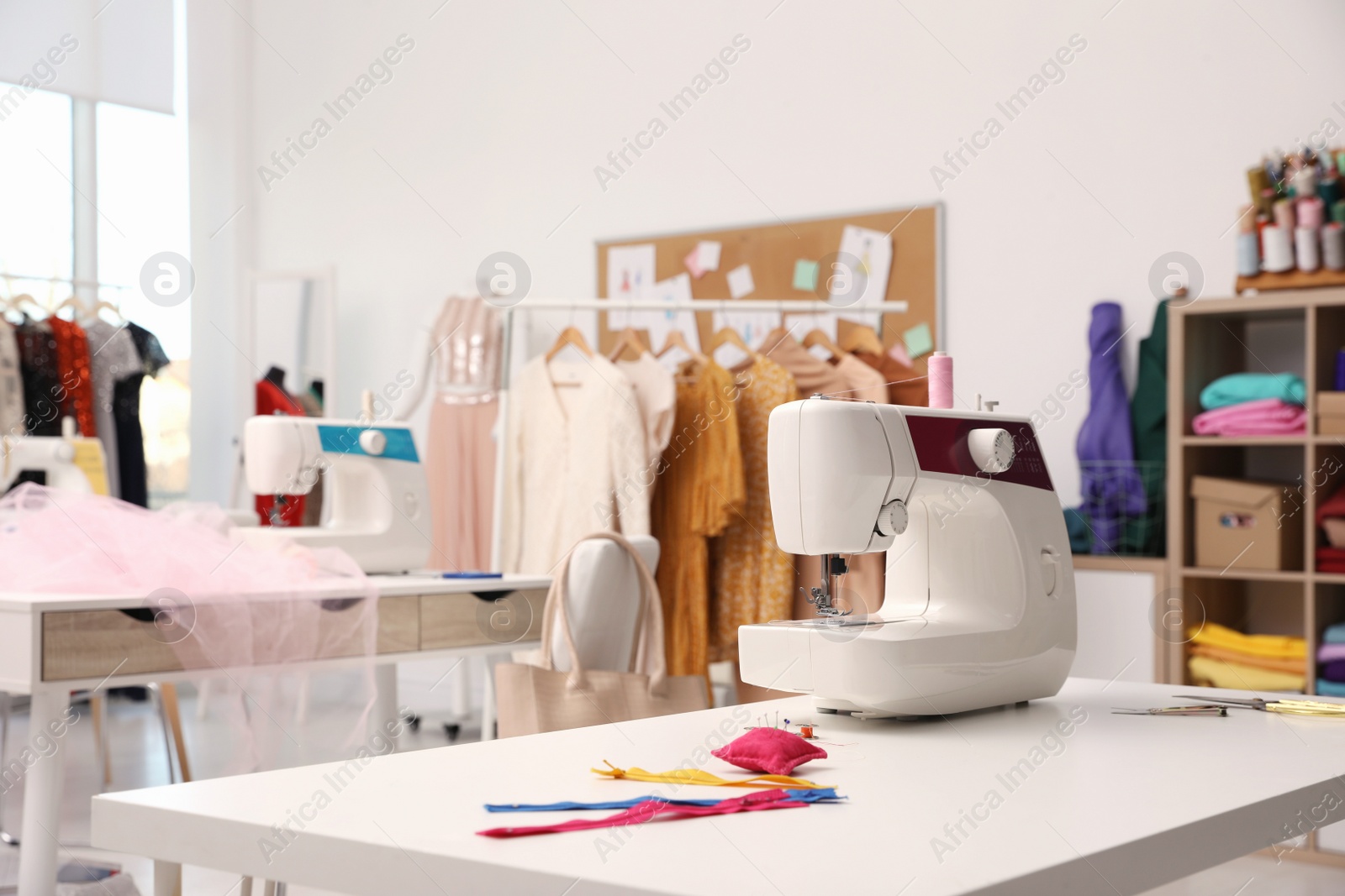 Photo of Sewing machine and accessories on table in dressmaking workshop