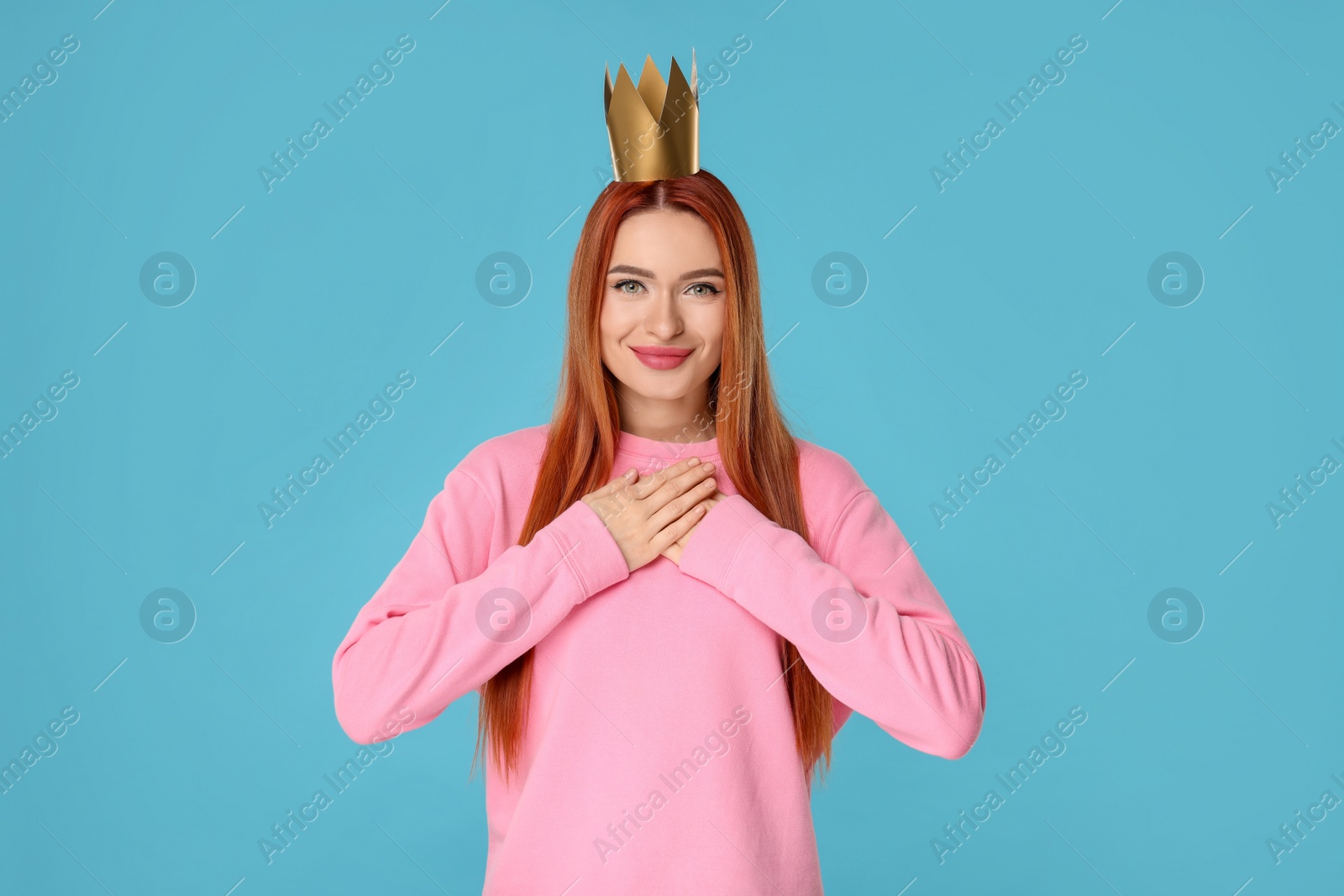 Photo of Beautiful young woman with princess crown on light blue background