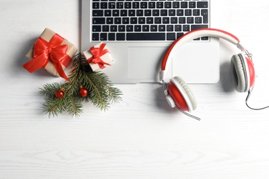 Flat lay composition with decorations, laptop and headphones on wooden background. Christmas music concept