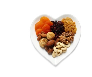 Photo of Heart shaped plate with different dried fruits and nuts on white background, top view. Space for text