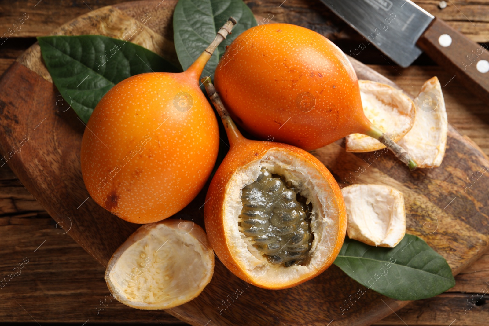 Photo of Delicious ripe granadillas on wooden table, flat lay