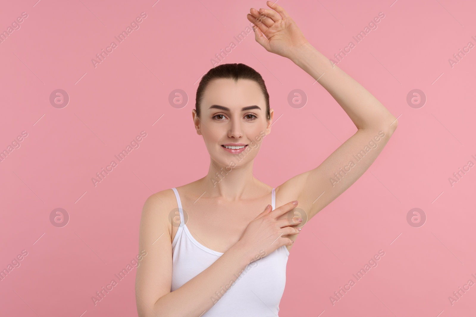 Photo of Beautiful woman showing armpit with smooth clean skin on pink background