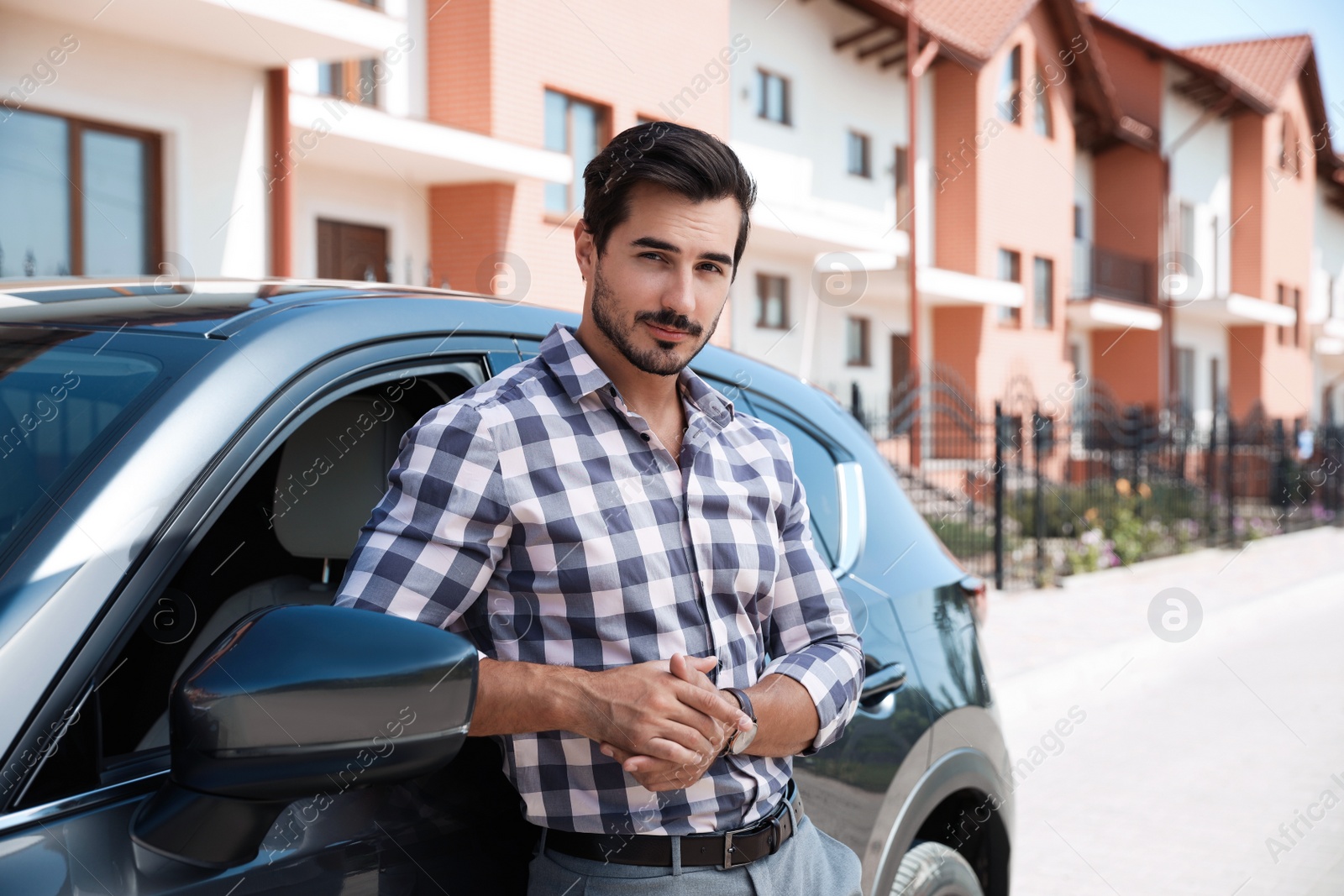 Photo of Attractive young man near luxury car outdoors