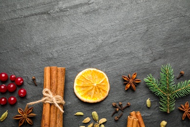 Photo of Flat lay composition with mulled wine ingredients and fir branch on black slate table. Space for text