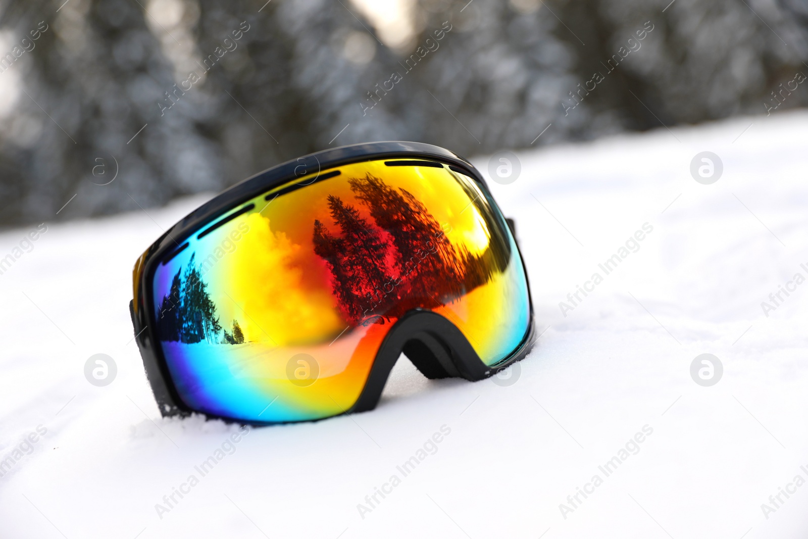 Photo of Stylish ski goggles on snow outdoors. Winter sport equipment