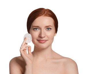 Beautiful woman with freckles holding cotton pad on white background