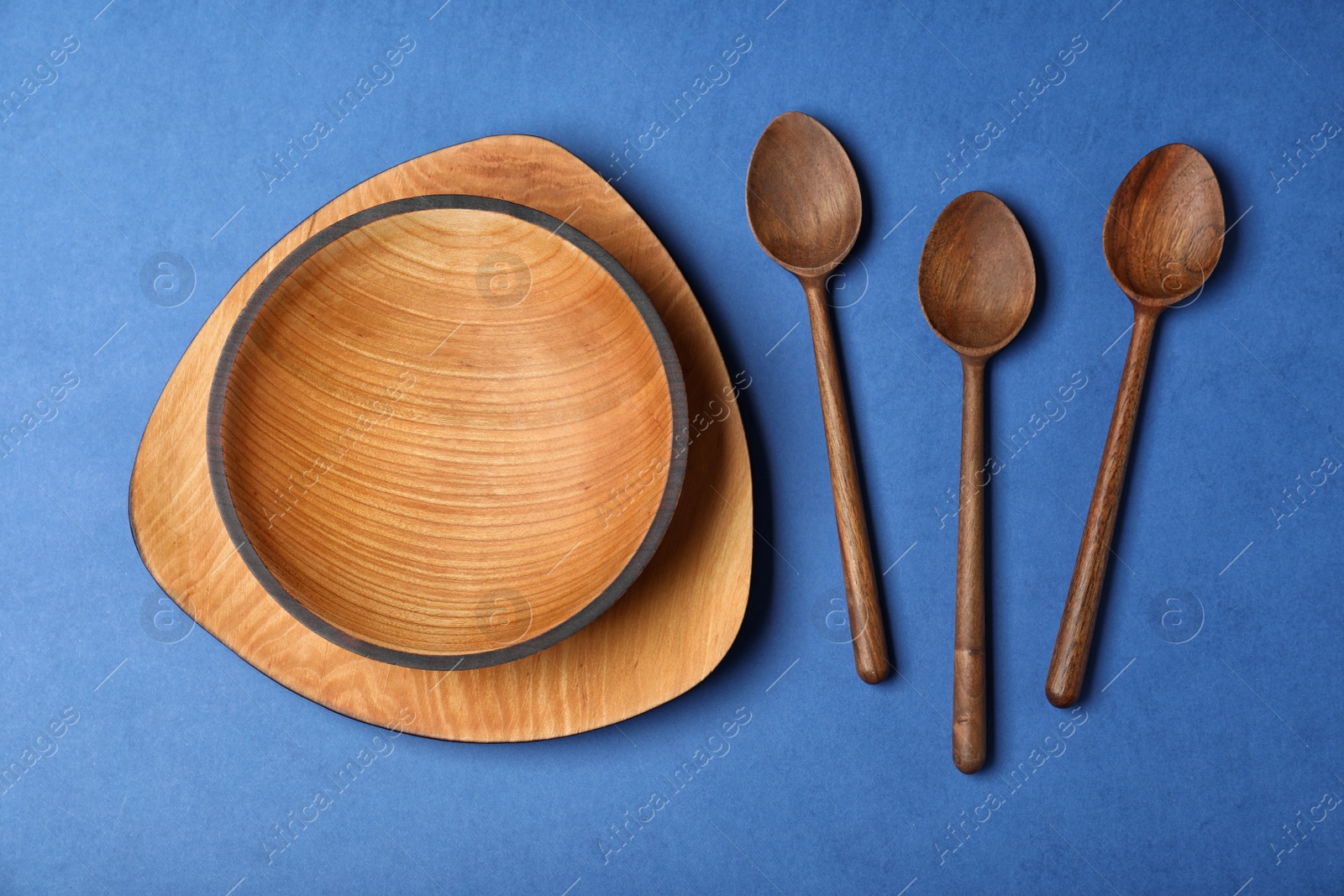 Photo of Flat lay composition with wooden kitchenware on blue background