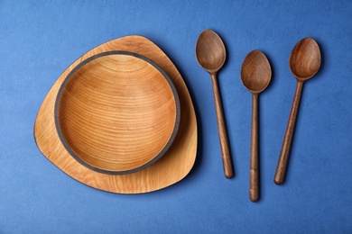 Flat lay composition with wooden kitchenware on blue background