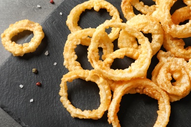 Homemade crunchy fried onion rings on table, top view