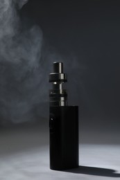 Photo of Electronic cigarette and smoke on dark grey background