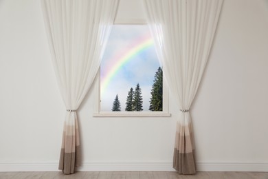 Image of View of beautiful rainbow in blue sky through window