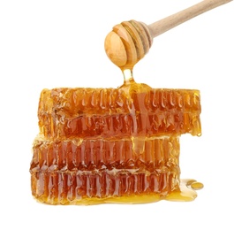 Photo of Honey pouring from dipper onto fresh combs against white background