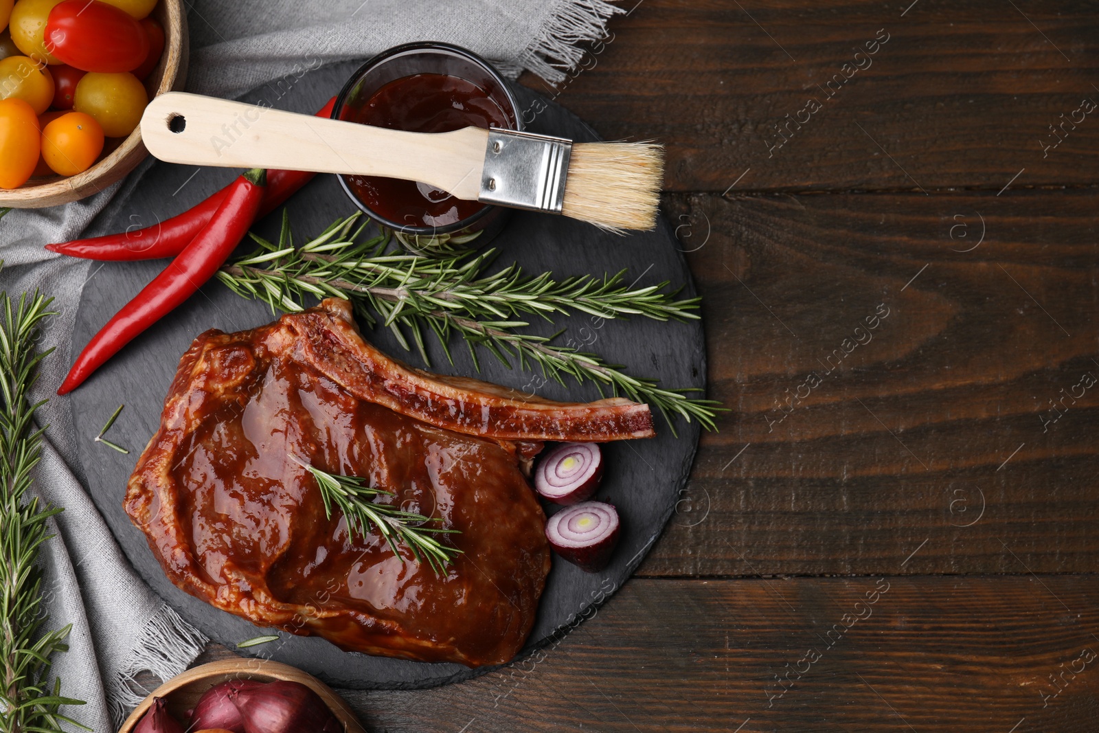 Photo of Tasty meat, rosemary, marinade and vegetables on wooden table, flat lay. Space for text