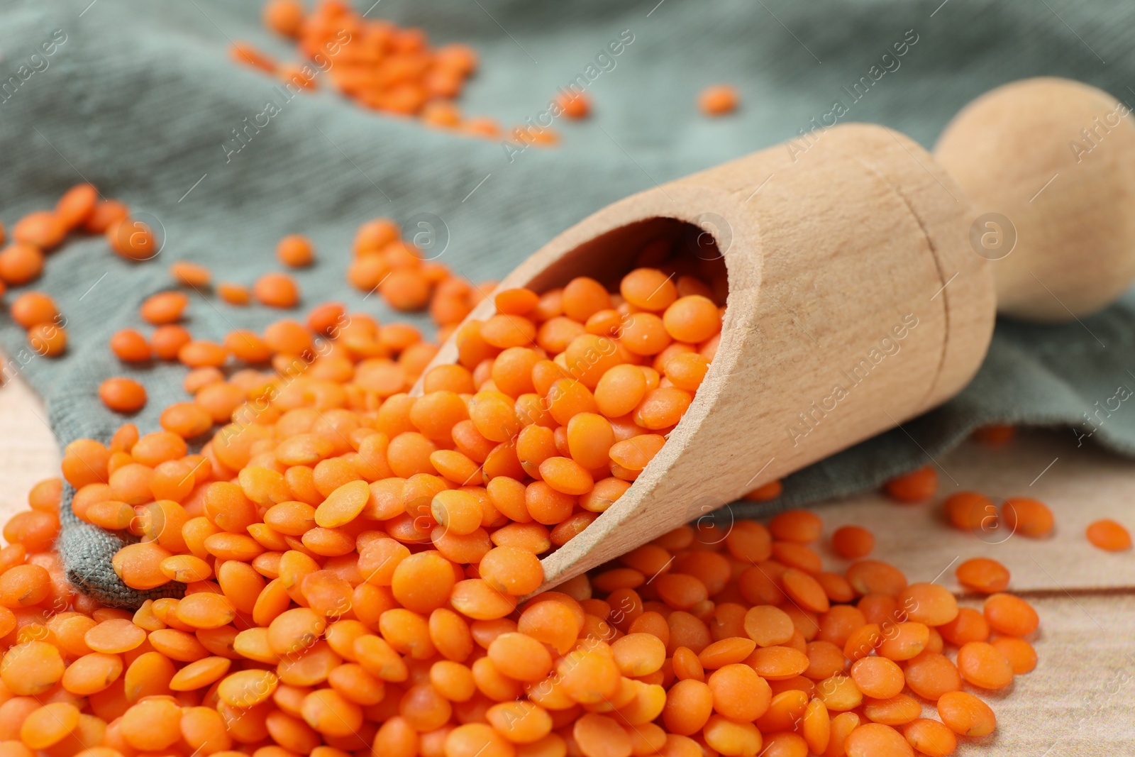 Photo of Scoop of raw lentils on table, closeup