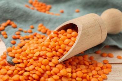 Scoop of raw lentils on table, closeup