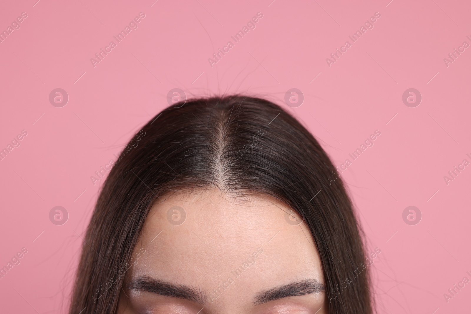 Photo of Woman with healthy dark hair on pink background, closeup