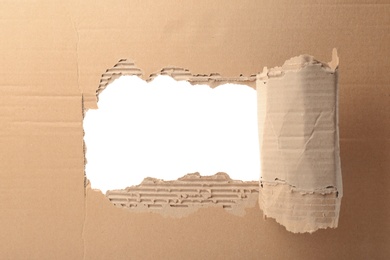 Photo of Hole in cardboard on white background. Recyclable material