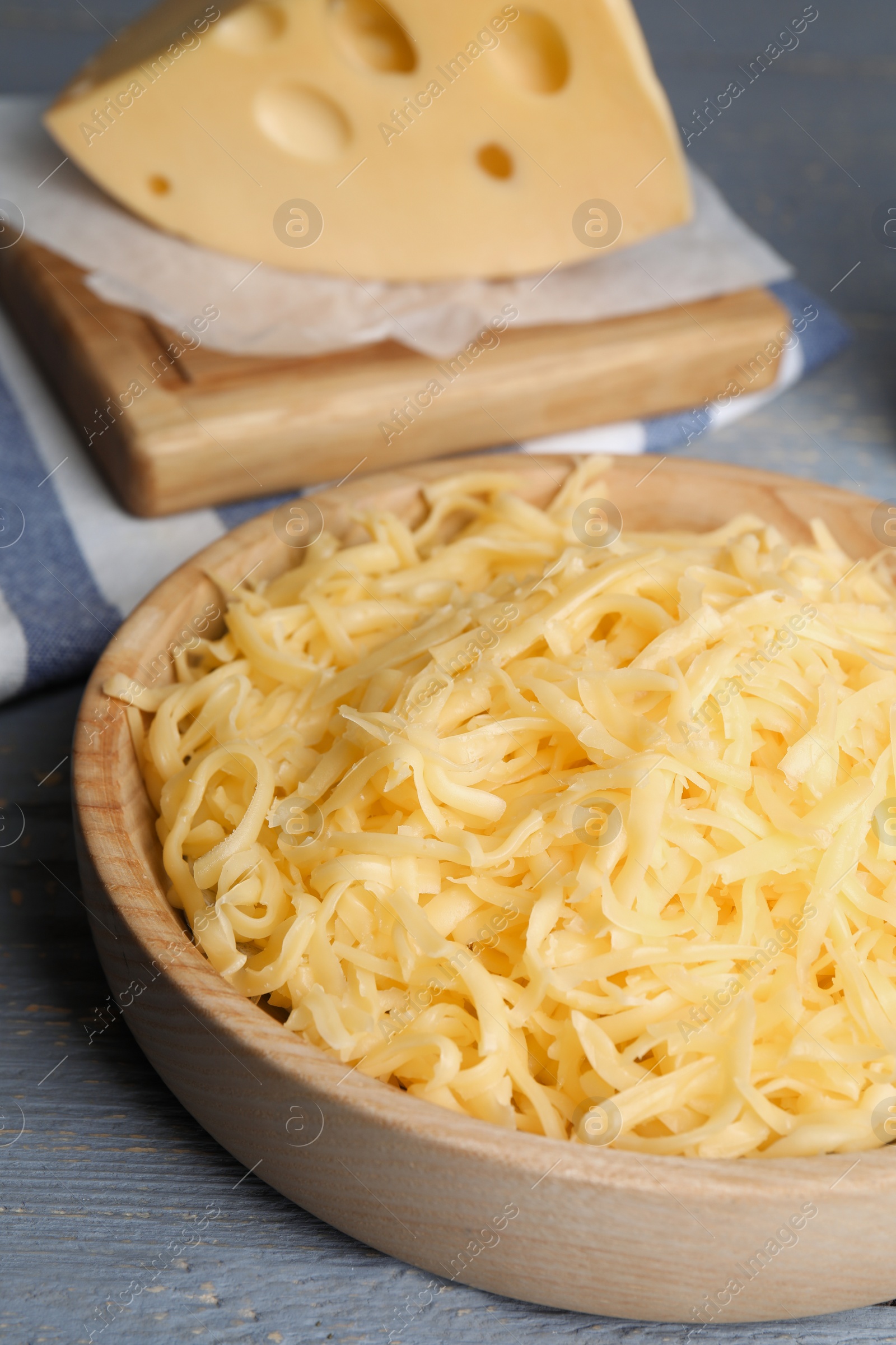 Photo of Tasty grated cheese on light grey wooden table