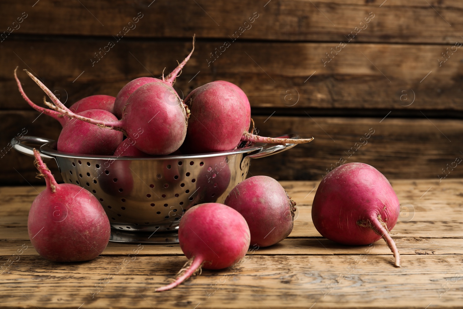 Photo of Raw red turnips on wooden table, closeup