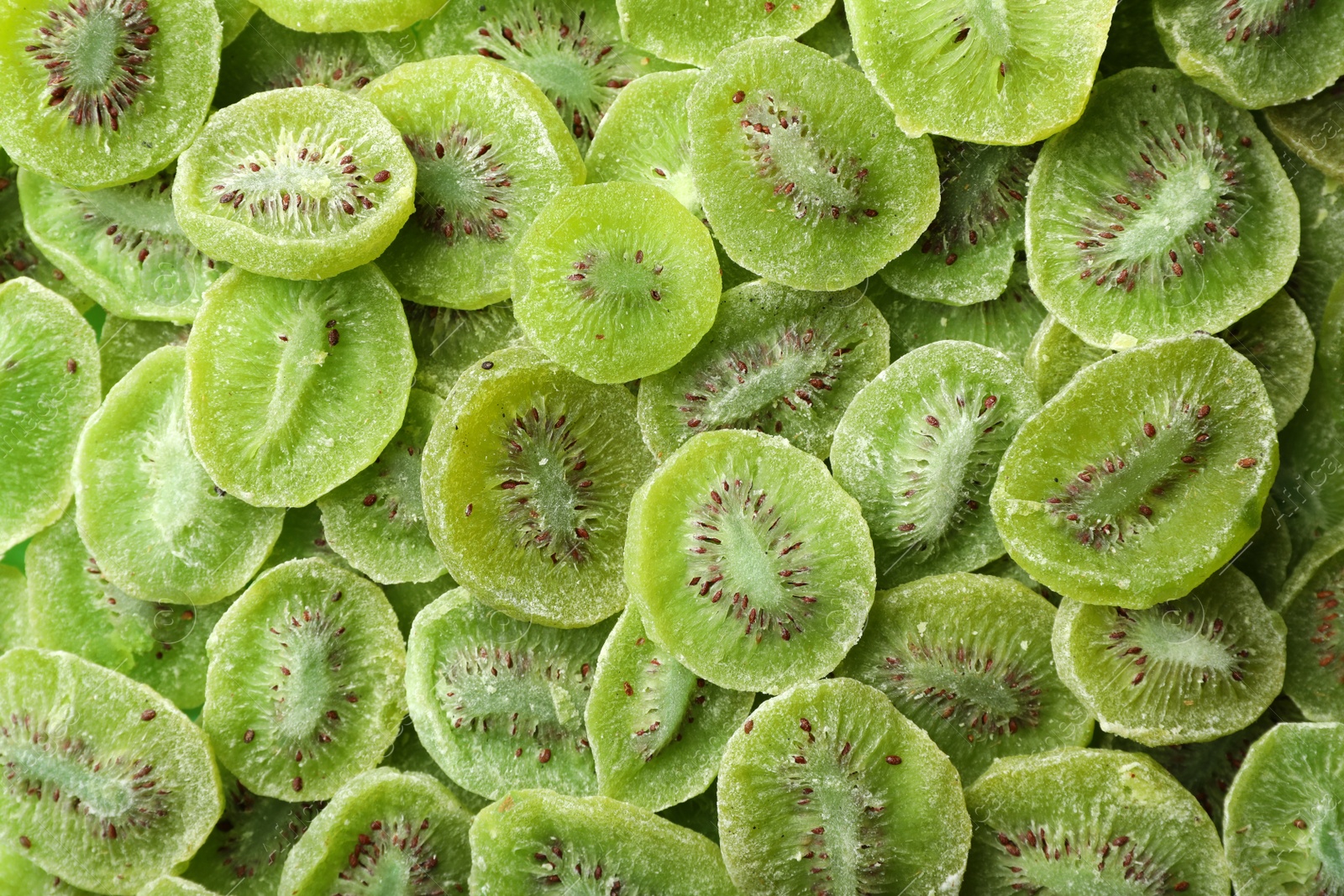 Photo of Tasty slices of kiwi as background, top view. Dried fruit as healthy food