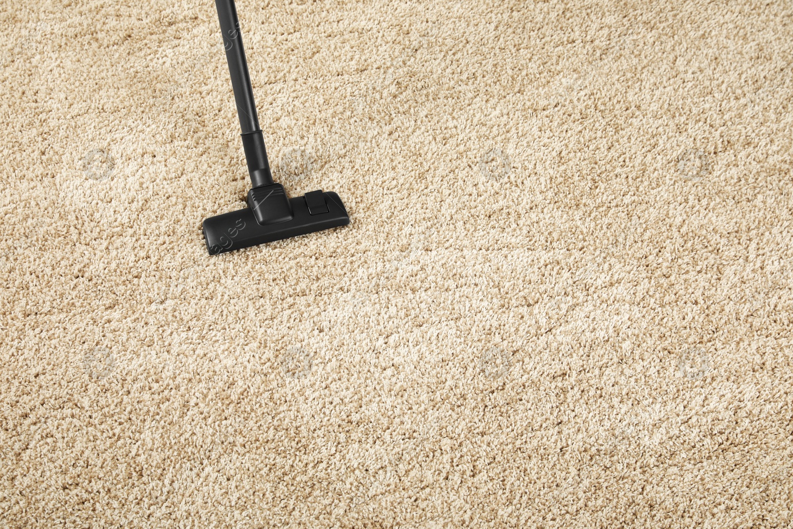 Photo of Removing dirt from beige carpet with modern vacuum cleaner. Space for text