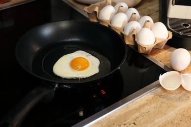 Cooking egg in frying pan for breakfast