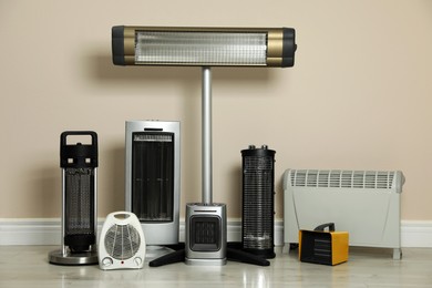 Photo of Different electric heaters near beige wall indoors