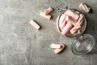 Photo of Glass jar with marshmallows on light grey table, flat lay. Space for text