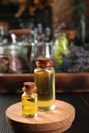 Photo of Bottles with herbal essential oils on wooden table. Space for text
